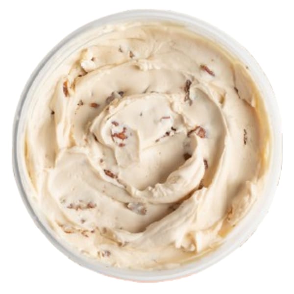 Overhead view of a container filled with creamy, light brown Ugly Bagel cinnamon cream cheese.