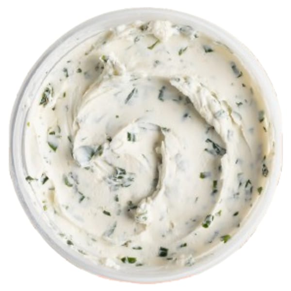Overhead view of a container of Ugly Bagel's cream cheese with green herbs mixed in.