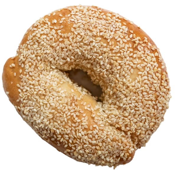 A golden-brown Ugly Bagel, generously covered with sesame seeds, on a white background.