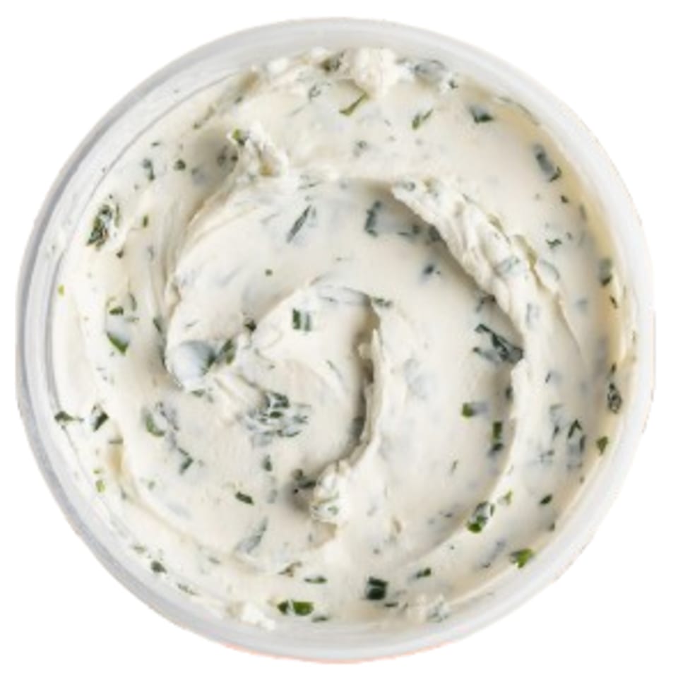 Overhead view of a container of Ugly Bagel's cream cheese with herbs.